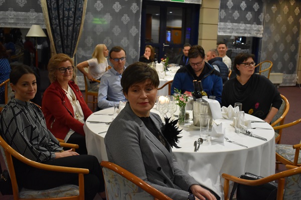Zdjęcia, a na nim grupa osób przy stole podczas uroczystej kolacji w trakcie Wielkopolskiego Forum Ekonomii Społecznej.
