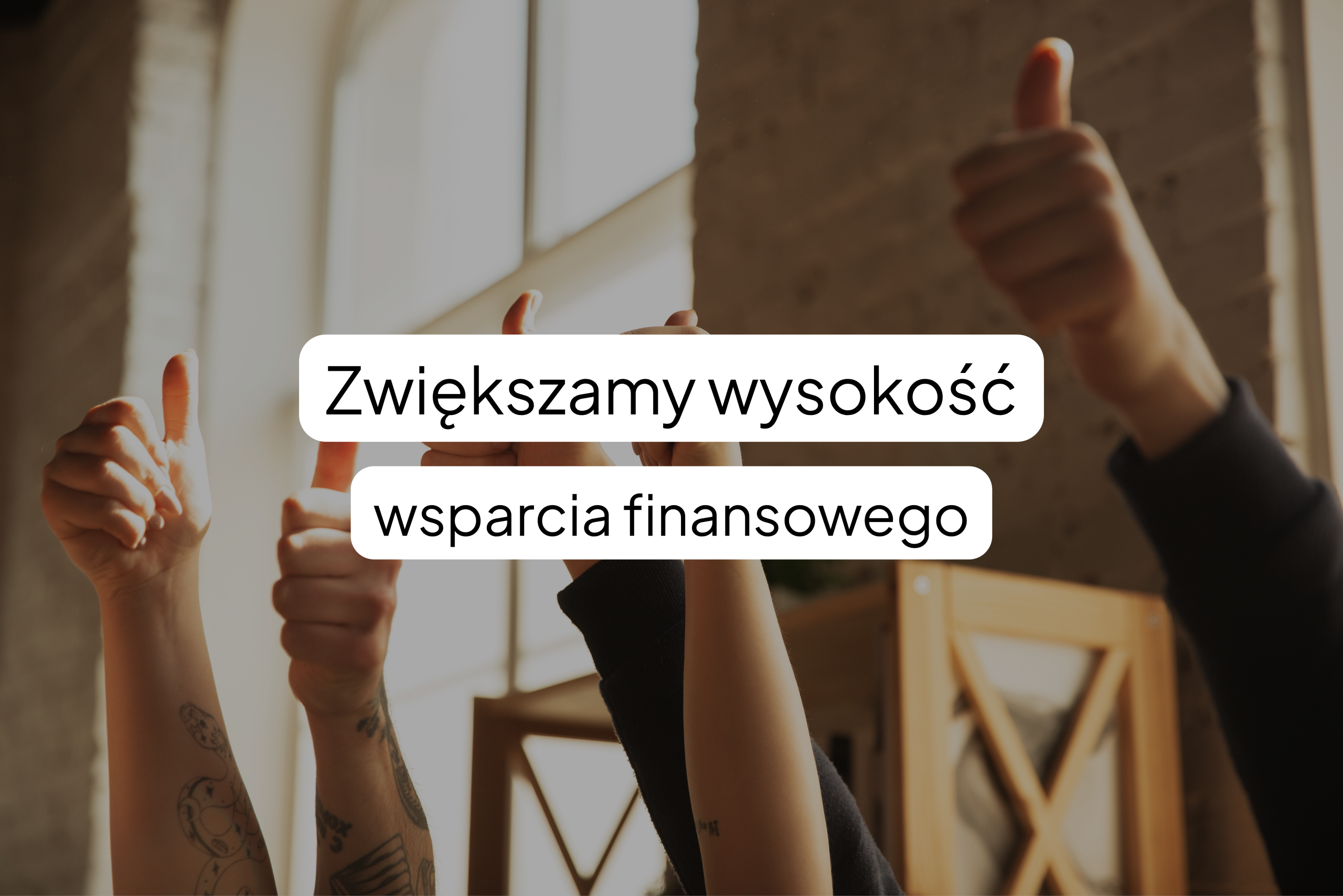 Kilka dłoni uniesionych w geście kciuka w górę na rozmytym tle wnętrza. Na pierwszym planie, w białych ramkach, znajduje się napis: „Zwiększamy wysokość wsparcia finansowego”.